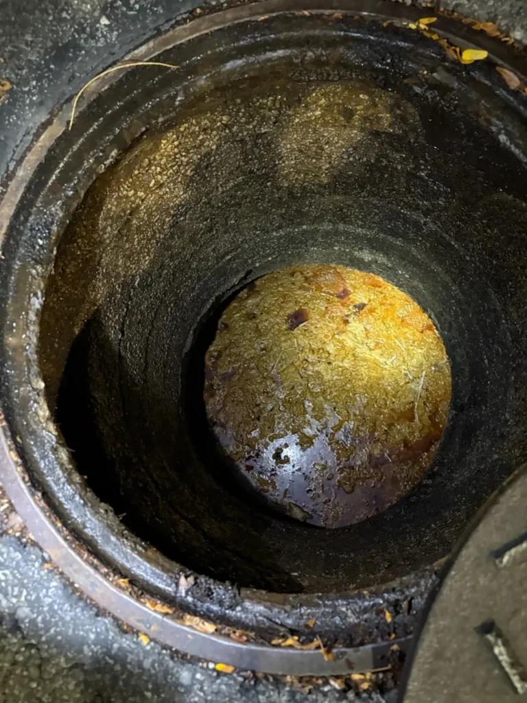 Open grease interceptor with a thick layer of floating grease before pumping