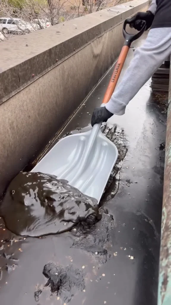 Shovel scraping grease from a restaurant roof
