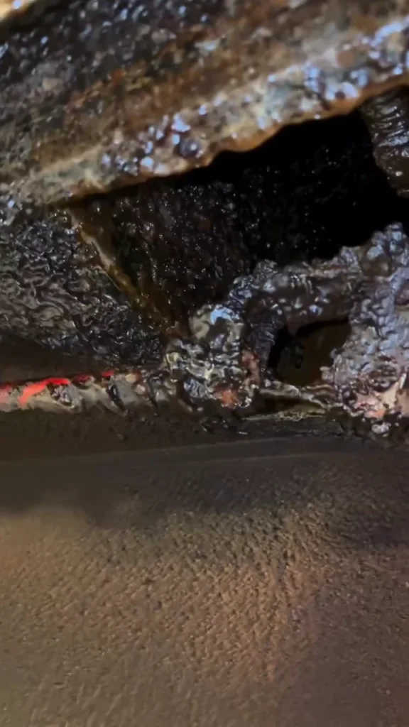 Thick grease buildup inside a kitchen hood plenum